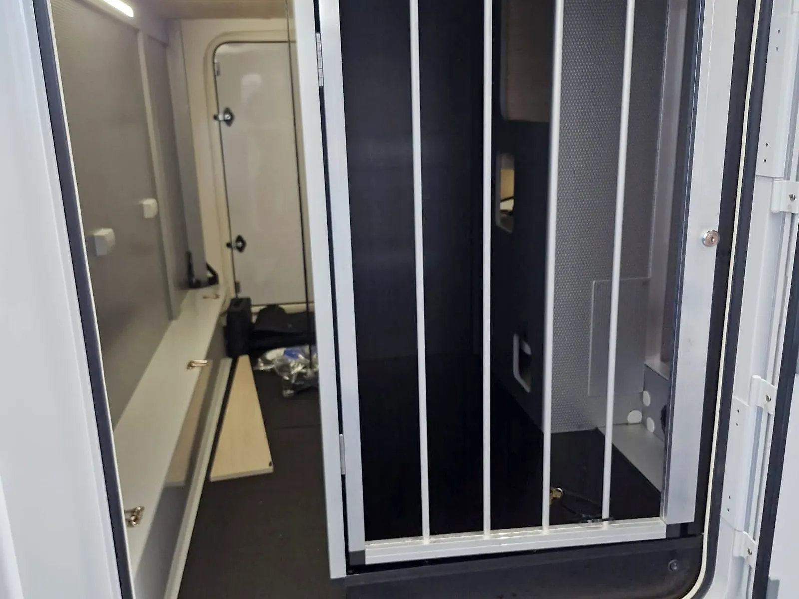 Hundeausbau in der Heckgarage eines Wohnmobils – abschließbare Aluminium-Gittertür von außen