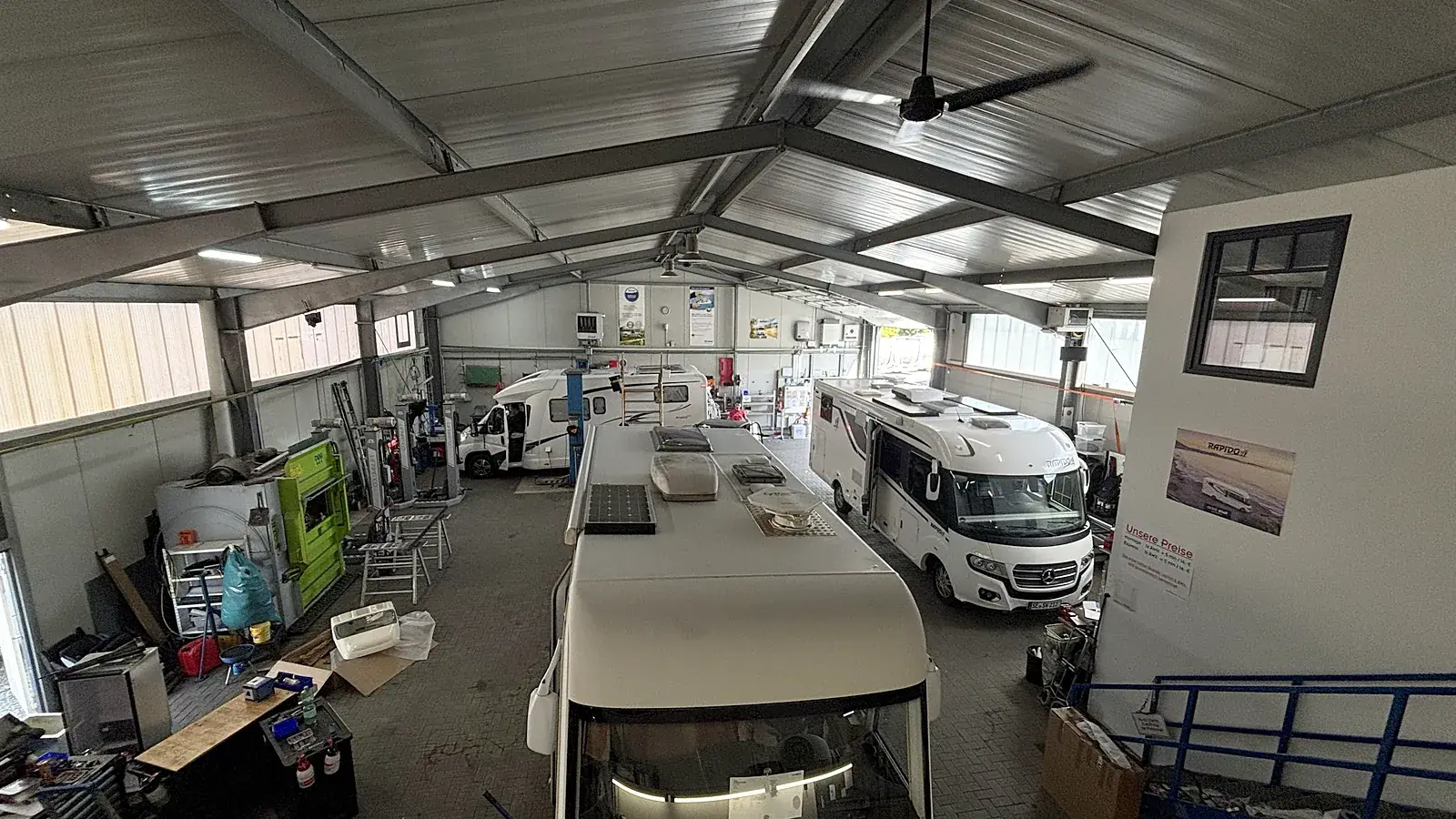 Werkstatthalle von Caravan Technik Mahl in Schuby mit mehreren Wohnmobilen auf der Hebebühne